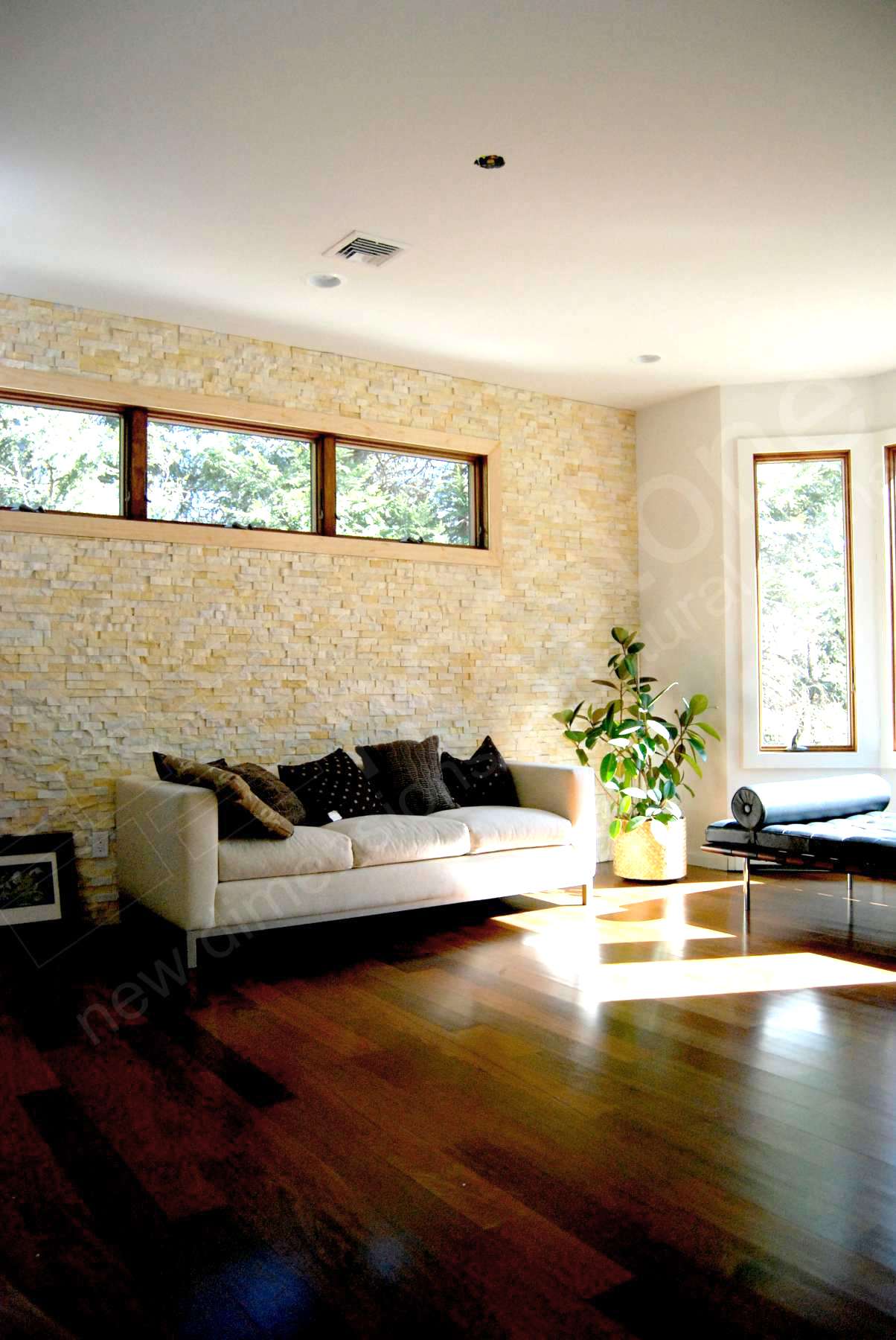 Natural Stone Feature Wall of Norstone Ivory Rock Panels with low slung couch and large window in a suburban NJ home for improved Indoor Air Quality